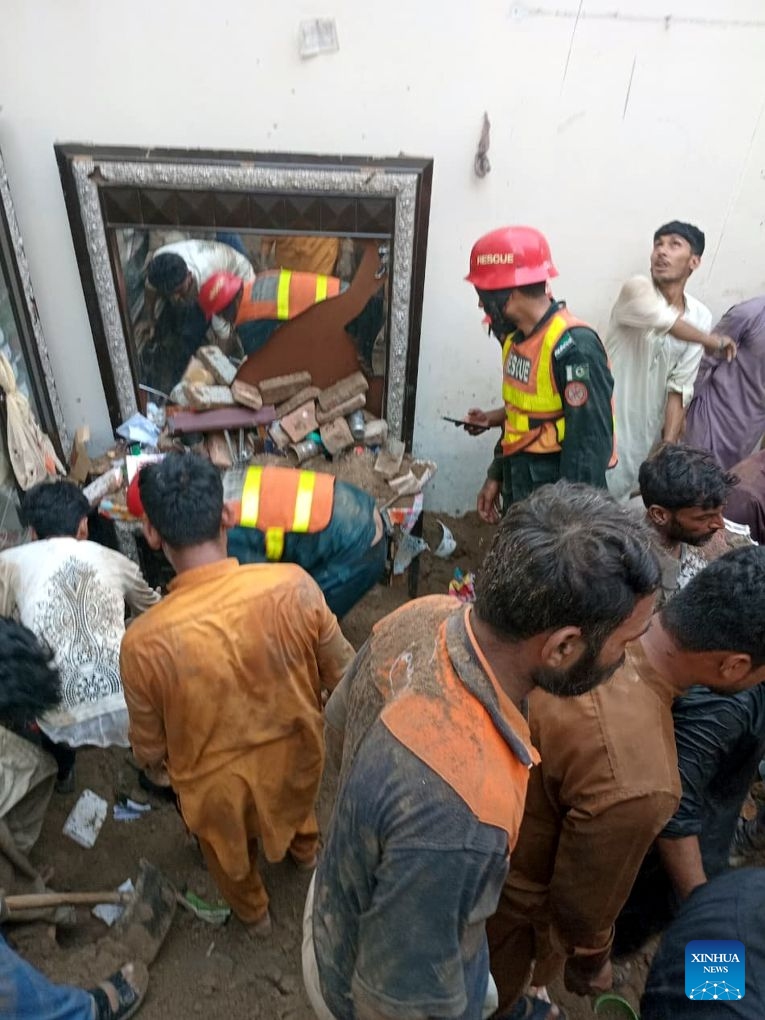 Photo taken with mobile phone shows rescuers working at the roof collapse site in Lahore, Pakistan on June 30, 2026. At least 14 children were killed and several others injured after the roof of a private tuition center collapsed in Pakistan's eastern city of Lahore on Tuesday. (Str/Xinhua)