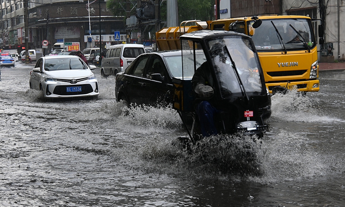 Electric bikes and vehicles wade through floodwaters on rain-soaked streets in Mudanjiang City, Northeast China's Heilongjiang Province on July 1, 2026. The city experienced urban flooding after intense short-term rainfall triggered by severe convective weather inundated parts of the city. Photo: VCG 