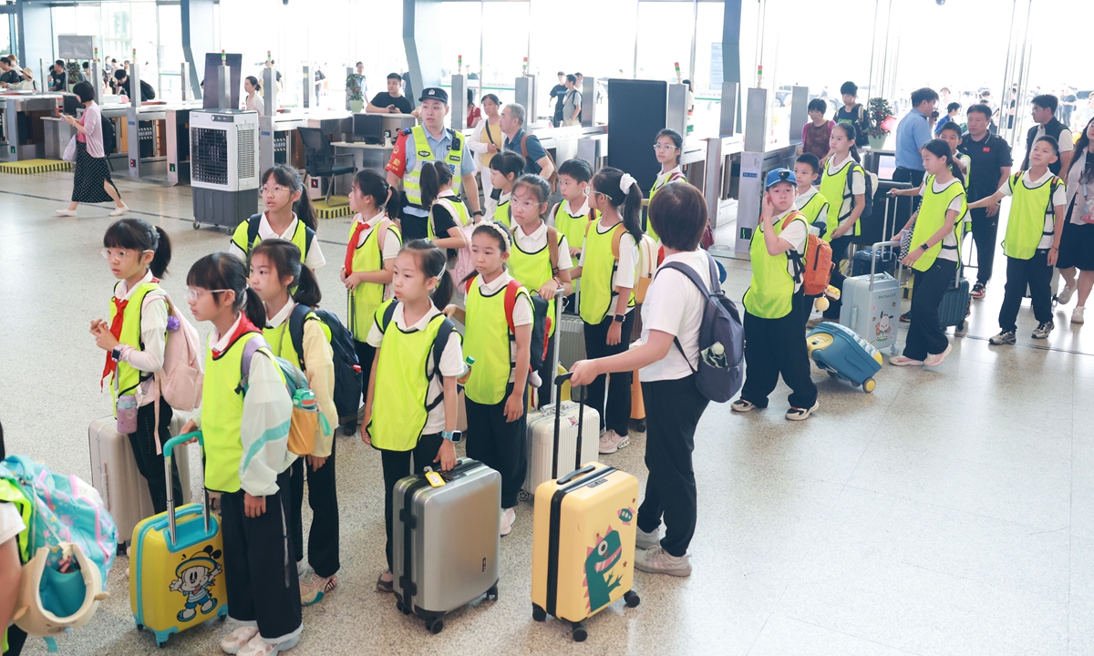 Children wearing safety vests line up with their luggage at a railway station on July 1, 2026, as China's 2026 summer travel rush officially begins. The 62-day summer travel season is expected to see 1.01 billion trips made on the country's railway network. Photo: VCG
