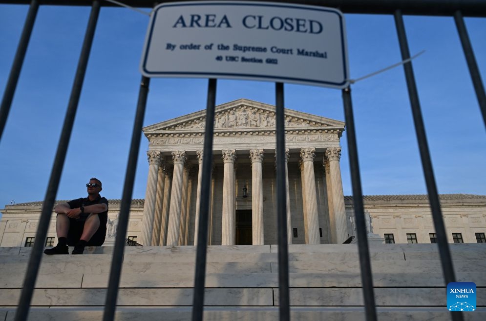 A man sits in front of the U.S. Supreme Court in Washington, D.C., the United States, on June 30, 2026. The U.S. Supreme Court on Tuesday rejected U.S. President Donald Trump's executive order denying birthright citizenship to children of undocumented immigrants or temporary residents, upholding birthright citizenship. (Xinhua/Li Rui)