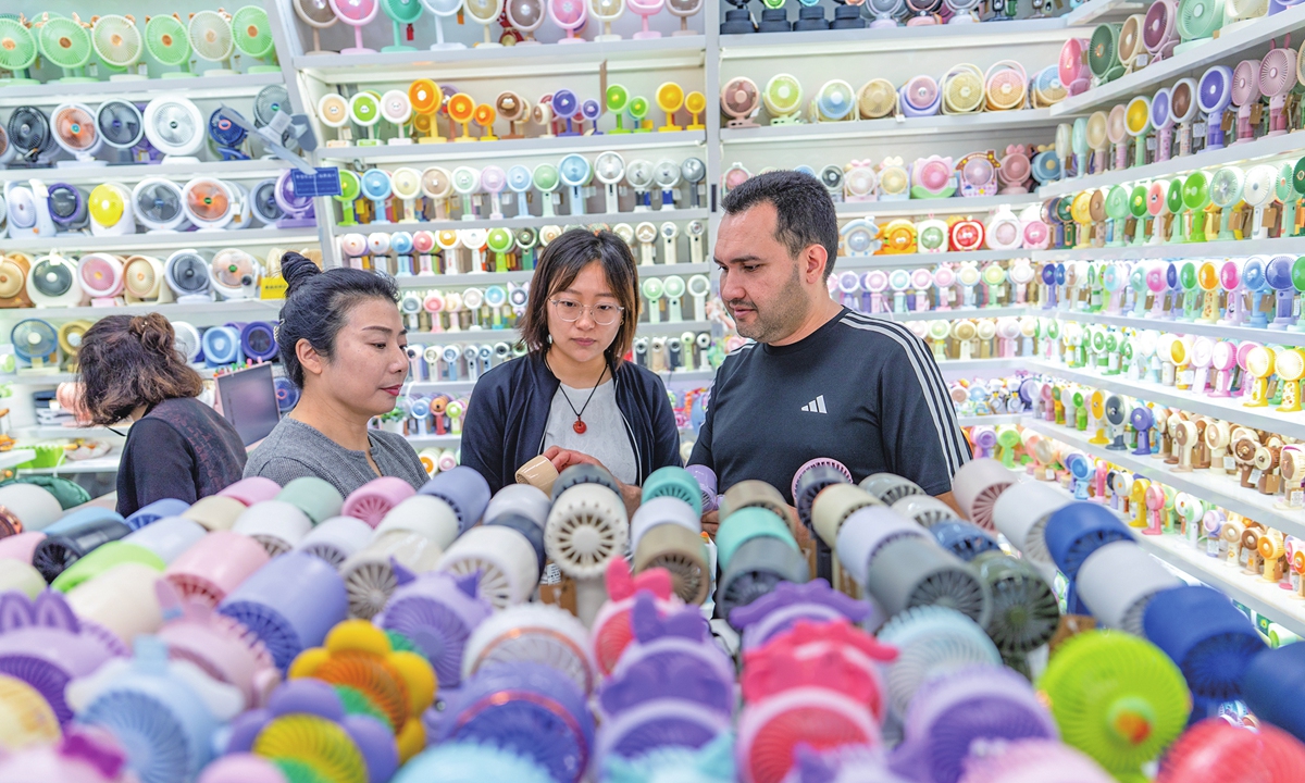 Buyers explore summer cooling products at a shop in Yiwu, East China's Zhejiang Province, on July 2, 2026. Amid the persistent heatwave in Europe, sales of heat-relief gadgets are booming. Products such as solar-powered fan hats, waist-mounted fans, AI-enabled desk fans, and portable air conditioners are highly popular among overseas buyers and are being exported to markets including Europe. Photo: VCG