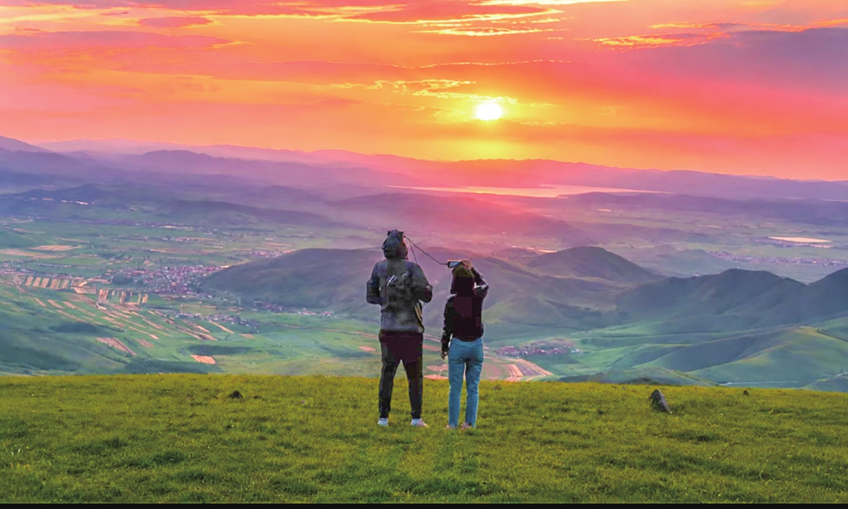 You Xiang and her friend watch the sunset at Bai Li Skyroad in the Fengning Manchu autonomous county, North China's Hebei Province, on June 20, 2026. Photo: Courtesy of You Xiang
