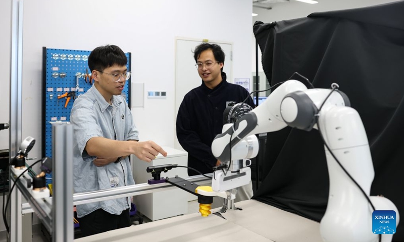 A student (L) talks with a teacher at the Hong Kong University of Science and Technology (Guangzhou) in Guangzhou, south China's Guangdong Province, June 30, 2026. Hong Kong University of Science and Technology (Guangzhou), which opened in 2022, has adopted an innovative academic structure featuring Hubs and Thrusts instead of traditional schools and departments, aiming to foster an interdisciplinary education model and advance emerging disciplines. (Photo: Xinhua)