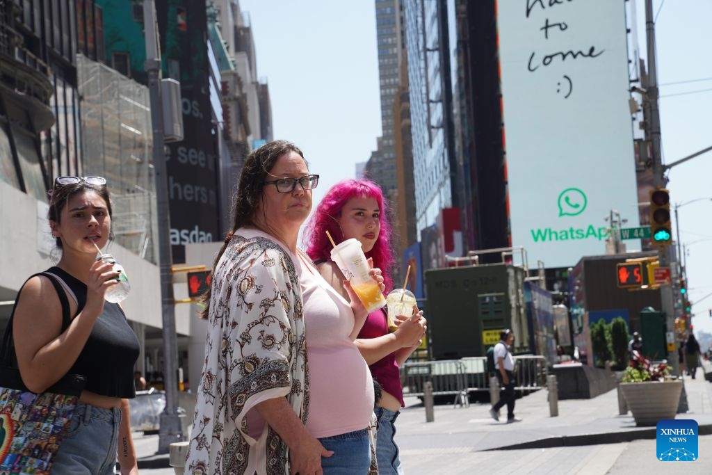 People with cold drinks wait to cross a street during a heat wave in New York, the United States, on July 2, 2026. (Xinhua/Zhang Fengguo)