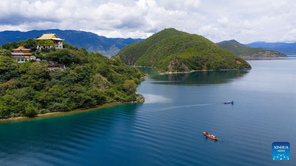 An aerial drone photo taken on July 3, 2026 shows tourists taking boats for sightseeing on Lugu Lake on the border between Ninglang Yi Autonomous County of Lijiang City in southwest China's Yunnan Province and Yanyuan County of Liangshan Yi Autonomous Prefecture in southwest China's Sichuan Province. In recent years, local authorities in the Sichuan-Yunnan border areas have continuously advanced ecological conservation of Lugu Lake and deepened collaborative management of the two provinces, yielding remarkable ecological results and steady growth in cultural and tourism industries. (Photo: Xinhua)
