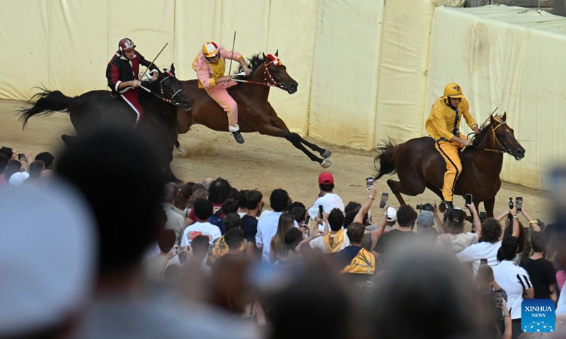 Palio jockey Giovanni Atzeni (R) , also known as Tittia, competes during the Palio in Siena, Italy, July 3, 2026. Palio in Siena, or Palio di Siena in Italian, is a historical horse race held twice a year in Siena since 1656. (Photo: Xinhua)