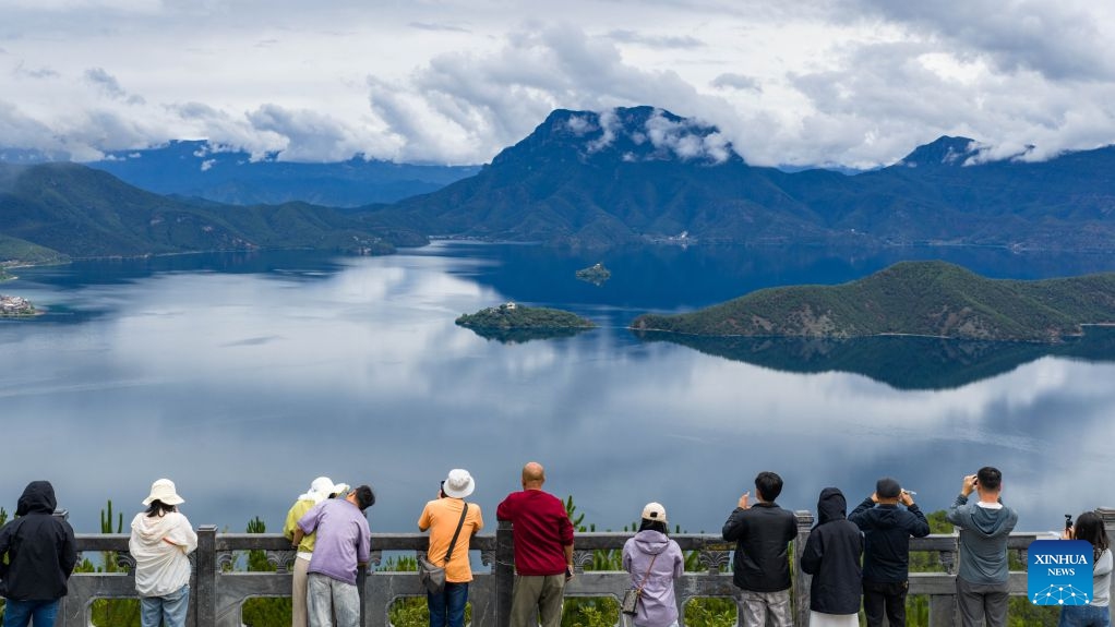Tourists take photos at Lugu Lake on the border between Ninglang Yi Autonomous County of Lijiang City in southwest China's Yunnan Province and Yanyuan County of Liangshan Yi Autonomous Prefecture in southwest China's Sichuan Province, July 3, 2026. In recent years, local authorities in the Sichuan-Yunnan border areas have continuously advanced ecological conservation of Lugu Lake and deepened collaborative management of the two provinces, yielding remarkable ecological results and steady growth in cultural and tourism industries. (Photo: Xinhua)