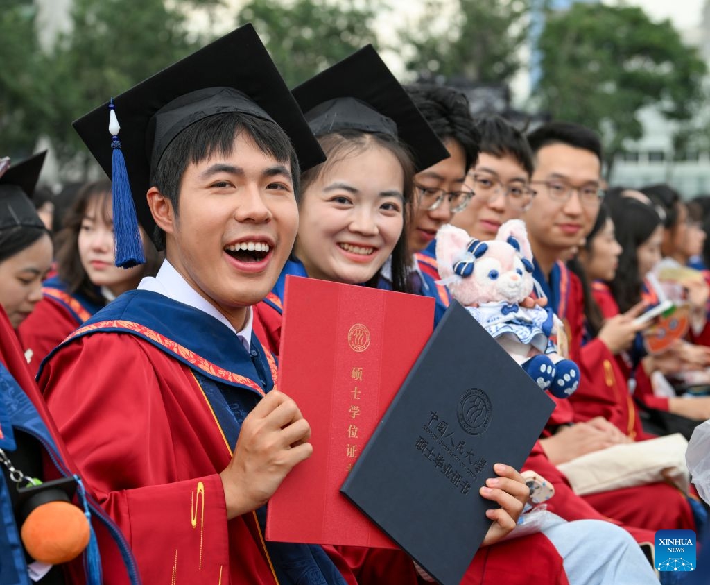 A student shows his graduation certificate and master's degree certificate during the graduation ceremony at Renmin University of China in Beijing, capital of China, July 4, 2026. Renmin University of China held the graduation ceremony on Saturday and saw about 8,244 graduates participating in the on-campus celebrations. (Photo: Xinhua)