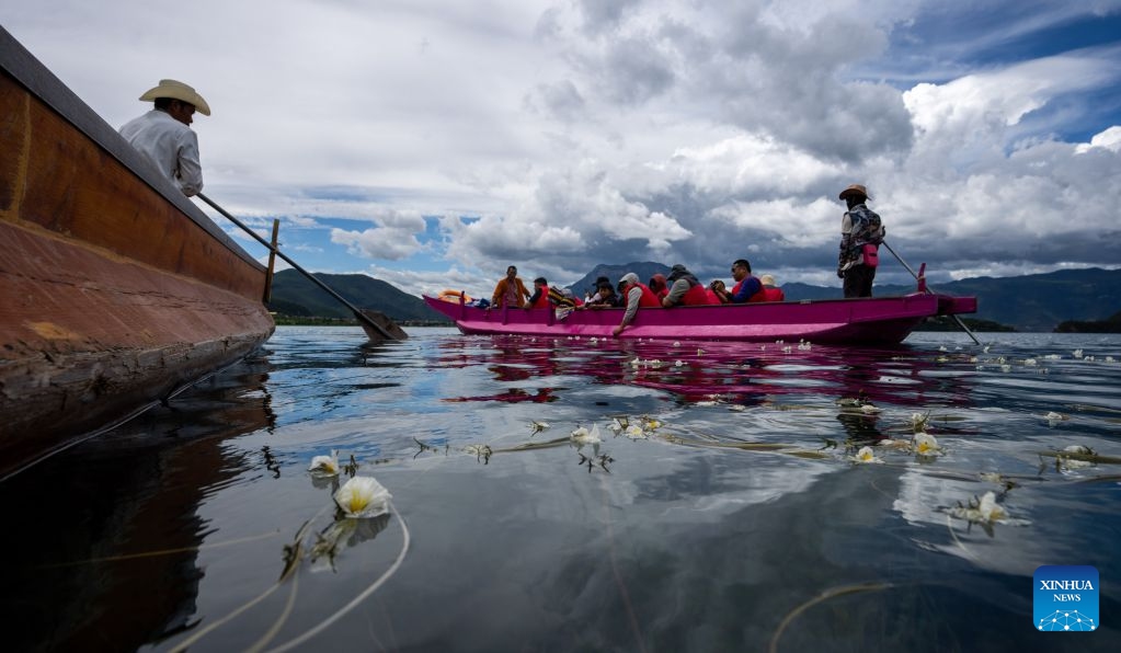 Tourists take a boat to view ottelia acuminata flowers on Lugu Lake on the border between Ninglang Yi Autonomous County of Lijiang City in southwest China's Yunnan Province and Yanyuan County of Liangshan Yi Autonomous Prefecture in southwest China's Sichuan Province, July 3, 2026. In recent years, local authorities in the Sichuan-Yunnan border areas have continuously advanced ecological conservation of Lugu Lake and deepened collaborative management of the two provinces, yielding remarkable ecological results and steady growth in cultural and tourism industries. (Photo: Xinhua)