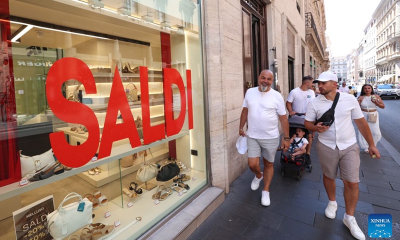 People walk past a shop with a sale advertisement on its window in Rome, Italy, July 4, 2026. Most regions across Italy have kicked off their summer sales. (Xinhua/Wang Kaiyan)
