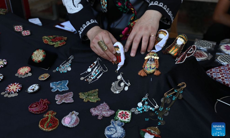 A vendor arranges products at the Harjeh Market in the West Bank city of Ramallah, July 3, 2026. The market is a vibrant cultural event that brings together a diverse selection of traditional handicrafts, handmade products, and local foods, offering visitors an opportunity to experience the richness and diversity of Palestinian heritage. It is held every Friday in Ramallah's Old Town from late June through early August. (Photo by Ayman Nobani/Xinhua)