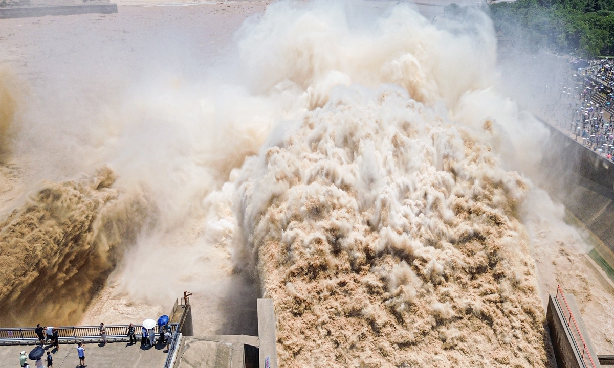 Visitors watch the spectacular water discharge at the Xiaolangdi Water Conservancy Project on the Yellow River in Luoyang, Central China's Henan Province, on July 5, 2026, during the water-sediment regulation operation, when increased flows are released to flush accumulated sediment downstream. Photo: VCG