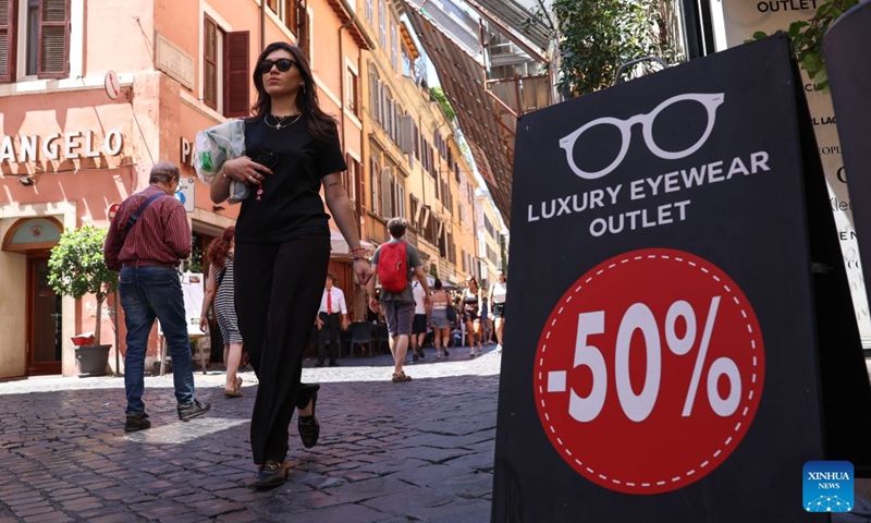 People walk by a sale advertisement of an eyewear shop in Rome, Italy, July 4, 2026. Most regions across Italy have kicked off their summer sales. (Xinhua/Wang Kaiyan)