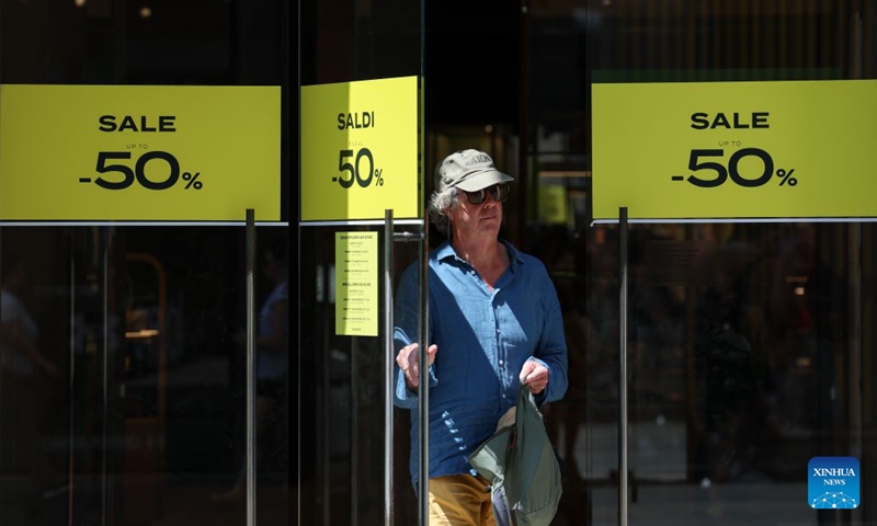 A woman leaves a shop with sale advertisements on its doors in Rome, Italy, July 4, 2026. Most regions across Italy have kicked off their summer sales. (Xinhua/Wang Kaiyan)
