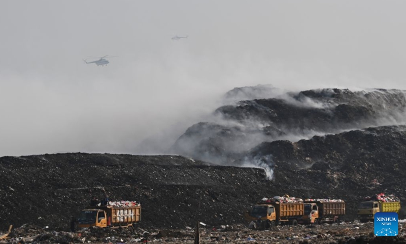 Helicopters with water bombing attempt to put out a fire at a smoldering landfill in Tangerang Regency of Banten Province, Indonesia on July 5, 2026.