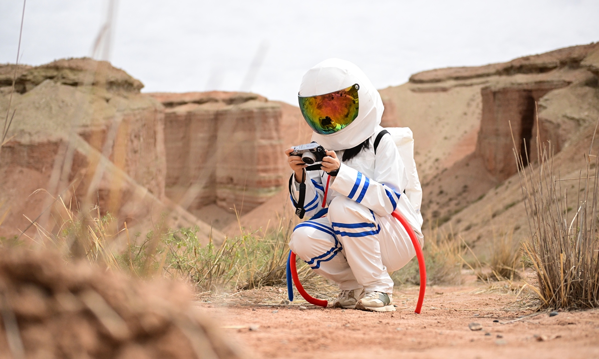 A tourist in spacesuit takes a photo inside a geopark themed on an alien valley outside of Zhangye, Northwest China's Gansu Province on July 6, 2026. The scenic area features natural landscapes that resemble the surface of an alien planet. From January to April, the province recorded 48,426 inbound visits by overseas tourists, a year-on-year increase of 52.6 percent. Photo: VCG