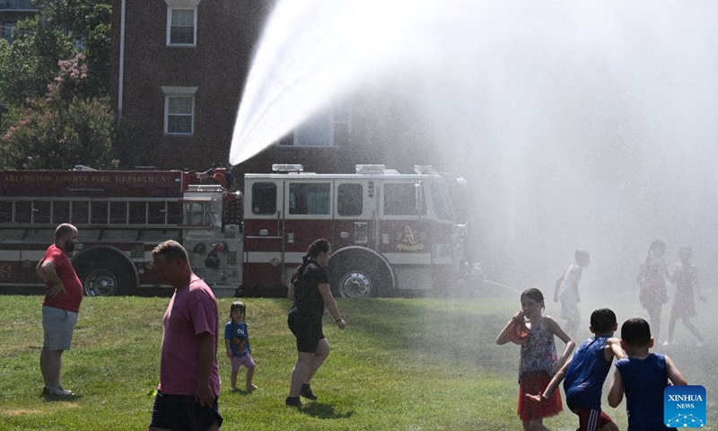 A firefighter sprays water from a truck to help people cool off as they wait for a flyover and a fireworks show to celebrate the 250th anniversary of the founding of the United States at a park in Arlington, Virginia, the United States, on July 4, 2026. (Photo: Xinhua)
