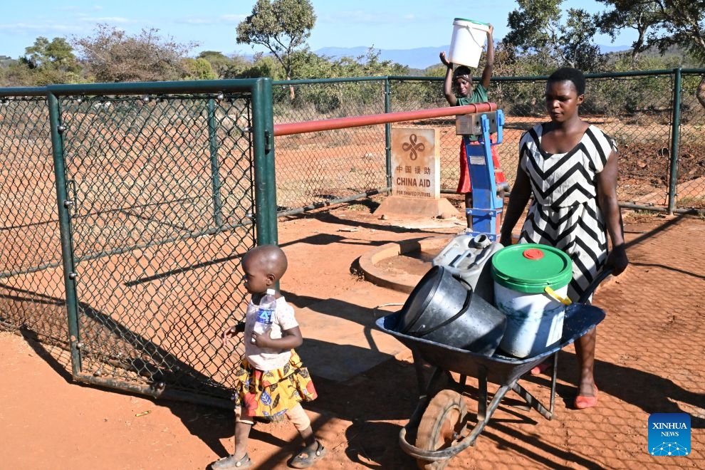 A woman pushes a wheelbarrow loaded with water containers away from a China-aided borehole in Bumba Village, Manicaland, Zimbabwe, June 29, 2026. (Photo: Xinhua)