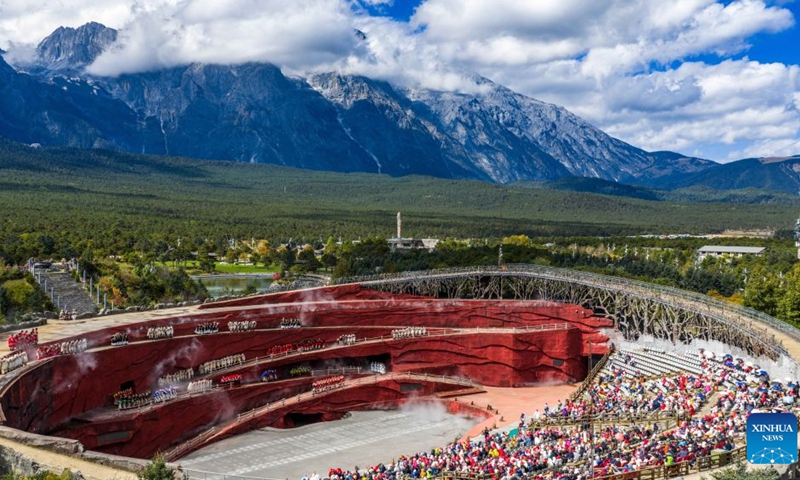 An aerial drone photo taken on Oct. 26, 2025 shows tourists watching a performance at the Yulong Snow Mountain scenic spot in Lijiang City, southwest China's Yunnan Province. On July 6, 1976, the Yunnan-Xizang Highway, a vital trunk road in China's southwestern border regions, was fully completed and opened to traffic. (Photo: Xinhua)