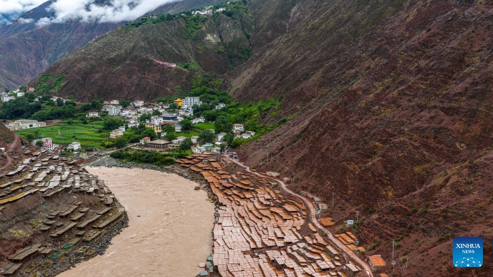 An aerial drone photo taken on July 1, 2026 shows salt fields alongside Lancang River in Mangkam County, Qamdo, southwest China's Xizang Autonomous Region. On July 6, 1976, the Yunnan-Xizang Highway, a vital trunk road in China's southwestern border regions, was fully completed and opened to traffic. Stretching 715 kilometers from Xiaguan County in Yunnan Province to Mangkam County in Xizang Autonomous Region, the route crosses the Jinsha and Lancang rivers, traverses the rugged and geologically complex Hengduan Mountains, and climbs over snow-capped passes. (Photo: Xinhua)