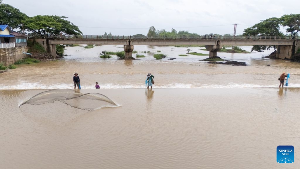 A drone photo shows fishermen casting their nets to catch fish in a lake in Savannakhet province, Laos, July 6, 2026. Located along the bank of the Mekong River, Laos' Savannakhet province boasts rich fishery resources in its lakes and reservoirs, where many fishermen continue to rely on traditional cast nets to make a living. (Photo: Xinhua)
