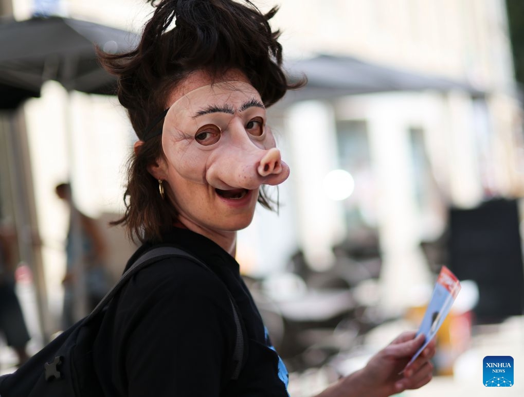 An artist promotes a drama on the street during the 80th Festival d'Avignon in Avignon, France, July 7, 2026. The festival, created in 1947 by French drama director Jean Vilar, is one of the most important contemporary performing arts events in the world. (Photo: Xinhua)