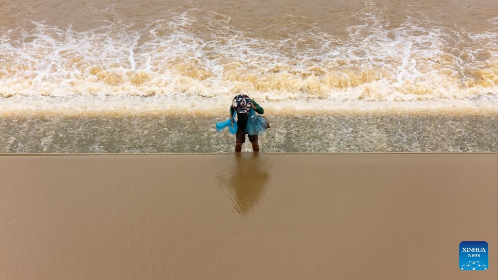 A drone photo shows a fisherman casting a net to catch fish in a lake in Savannakhet province, Laos, July 6, 2026. Located along the bank of the Mekong River, Laos' Savannakhet province boasts rich fishery resources in its lakes and reservoirs, where many fishermen continue to rely on traditional cast nets to make a living. (Photo: Xinhua)