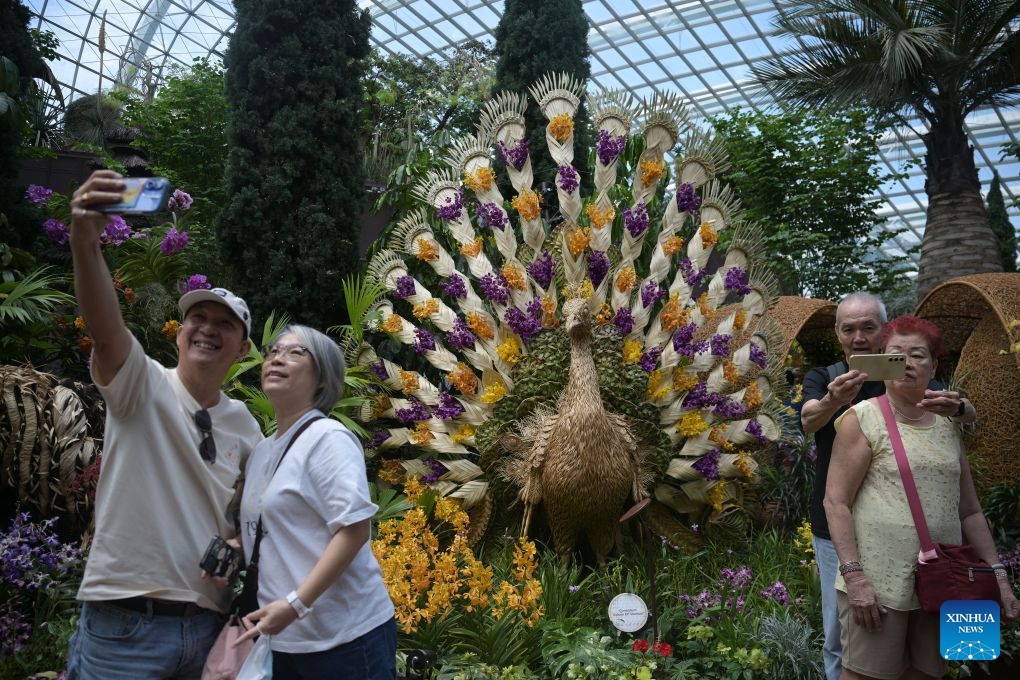 People pose for photos with orchids from around the world during two orchid exhibitions at Gardens by the Bay in Singapore on July 7, 2026. (Photo: Xinhua)