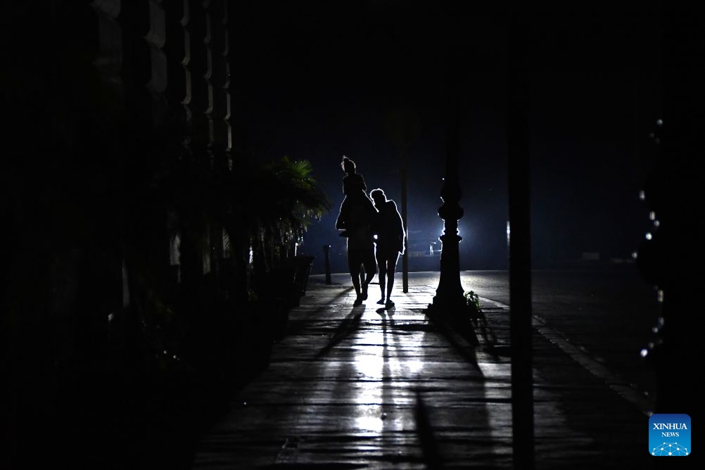 People walk down a dark street amid a nationwide blackout, in Havana, the capital of Cuba, in the small hours of July 7, 2026. Cuba's state-run National Electric Union said Monday that the country's national power system suffered a total outage. (Photo: Xinhua)