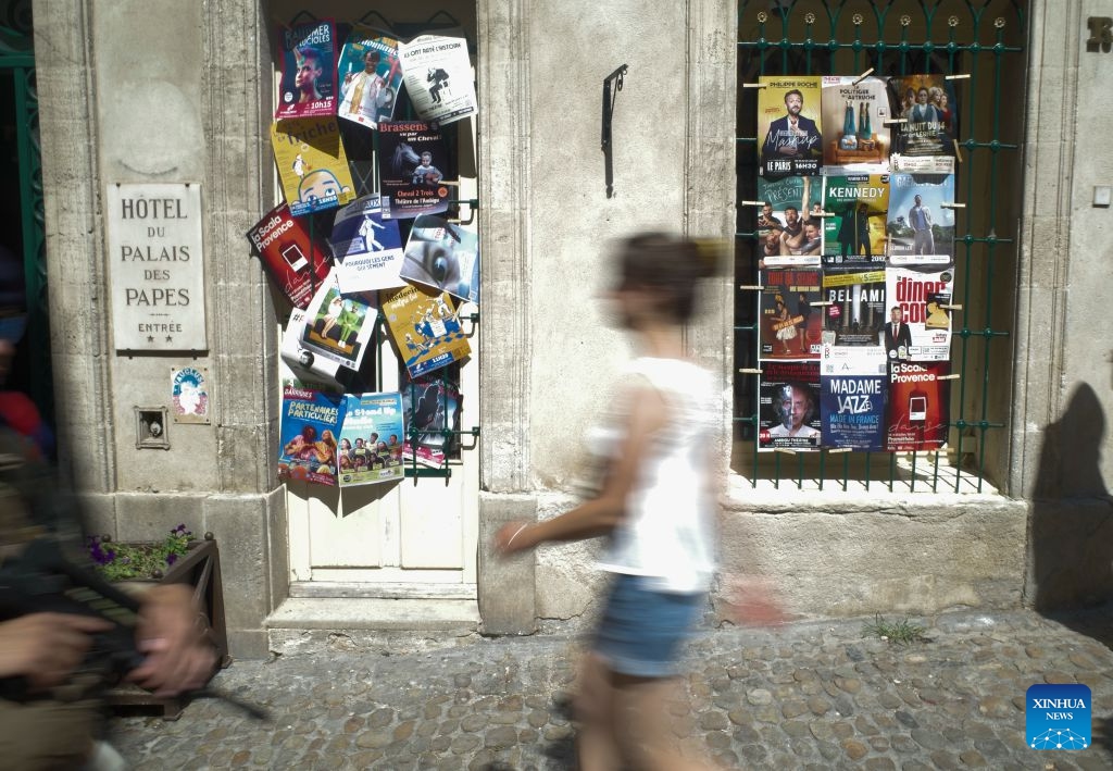 People walk past posters during the 80th Festival d'Avignon in Avignon, France, July 7, 2026. The festival, created in 1947 by French drama director Jean Vilar, is one of the most important contemporary performing arts events in the world. (Photo: Xinhua)