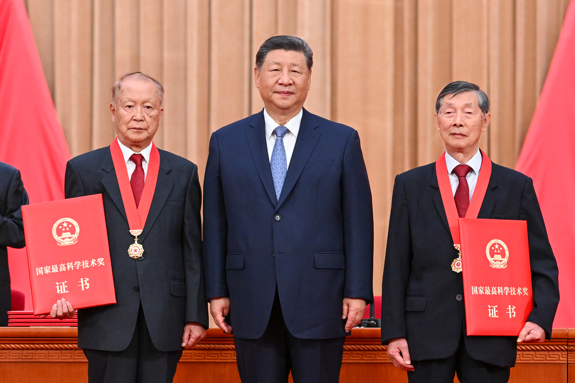 Chinese President Xi Jinping stands with radar technology expert Ben De (left) and founder of China's lithium battery sector Chen Liquan (right) as the two academicians are presented with China's top sci-tech award for the year 2025 in Beijing on July 8, 2026. Photo: Xinhua