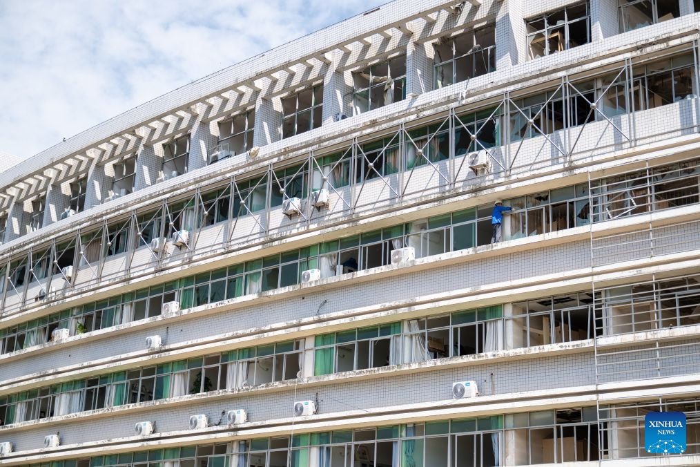 A staff member removes broken windows in Huanggang Normal University of Huanggang City in central China's Hubei Province, July 8, 2026. A tornado struck the urban area of Huanggang City on Monday, causing damage to multiple buildings of Huanggang Normal University. Following the disaster, the university immediately carried out emergency response overnight. On Tuesday, the university started to evacuate students in batches from the campus. Currently, all resettlement and restoration efforts are progressing in an orderly manner. (Photo: Xinhua)