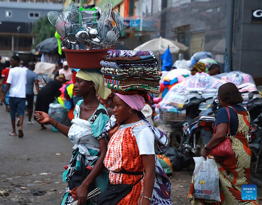 Women carry daily necessities and local fabrics for sale along the street in Abidjan, Cote d'Ivoire, on July 9, 2026. (Photo: Xinhua)