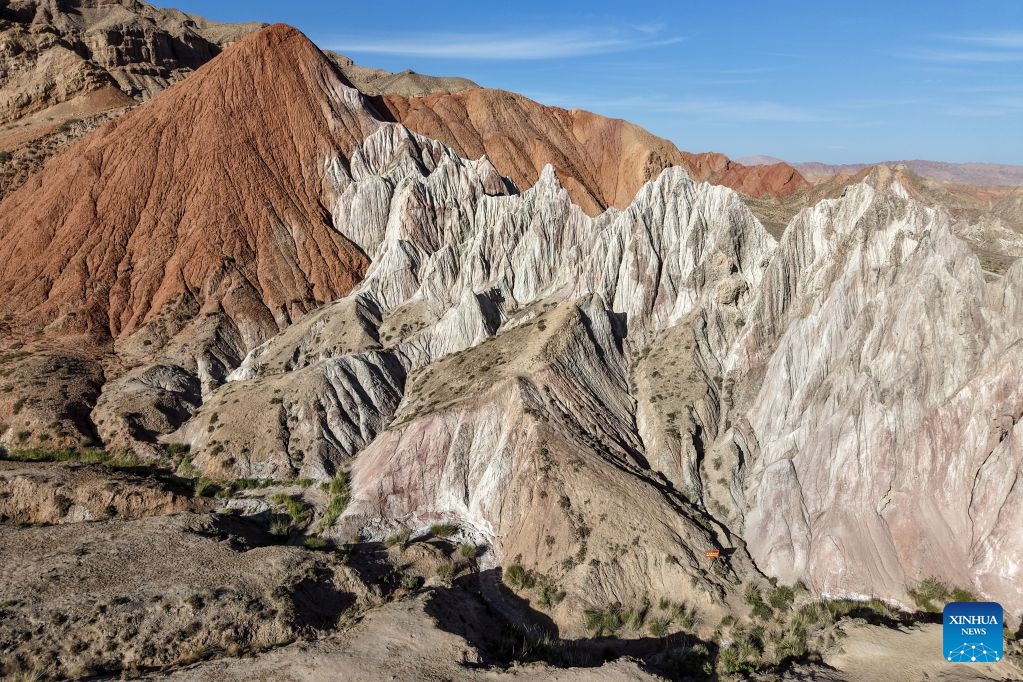An aerial drone photo taken on July 7, 2026 shows the view of a geopark in Sunan Yugur Autonomous County of Zhangye, northwest China's Gansu Province. The geopark covers an area of 17.34 square kilometers. The park features unique landforms with towering peaks, rugged mountains, jagged rock pillars, and vibrant colors. (Photo: Xinhua)