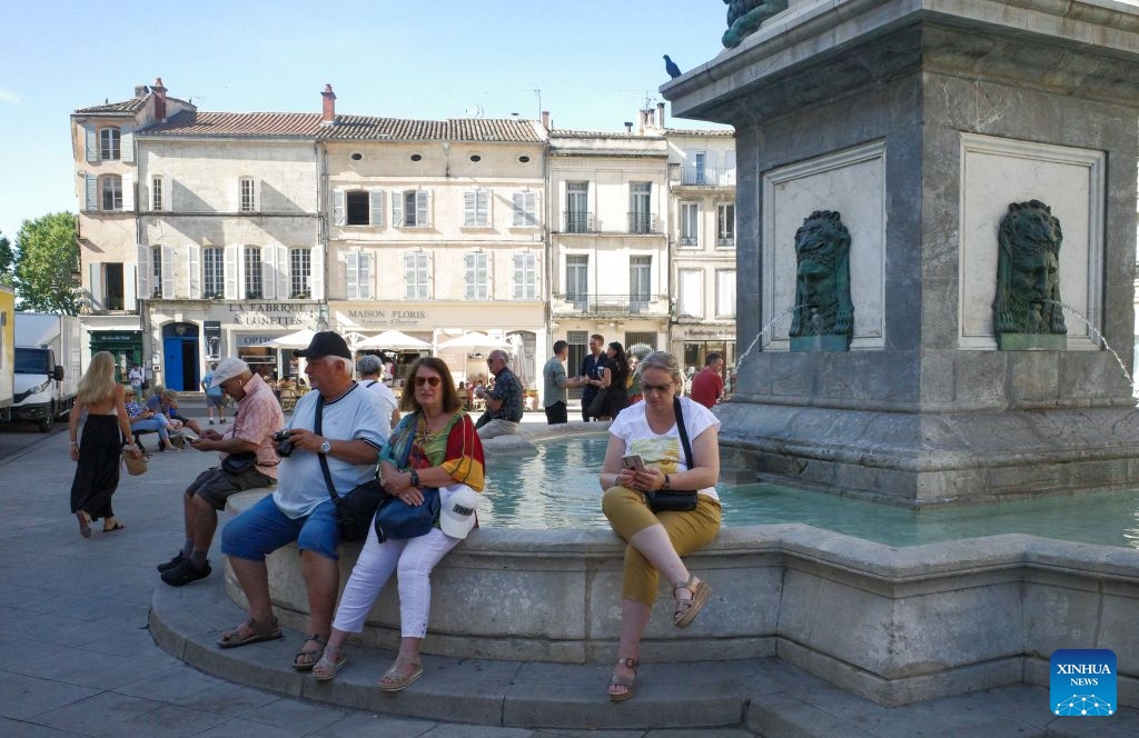 People relax near a fountain in Arles, France, July 8, 2026. France has experienced high temperatures this summer. (Photo: Xinhua)