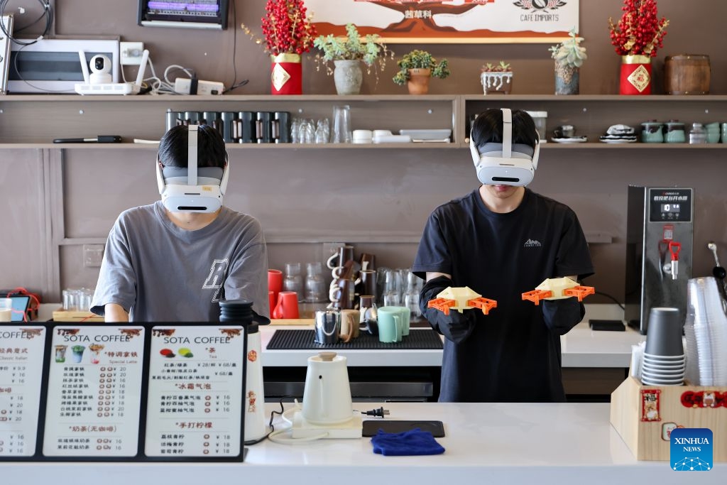 Data collectors capture real-world inputs for embodied intelligent devices at a cafe scenario in Yunyan District of Guiyang City, southwest China's Guizhou Province, July 6, 2026. With the rapid development of embodied artificial intelligence (AI), a new profession, trainers of embodied AI, has emerged, which comprise roles such as data collectors. (Photo: Xinhua)