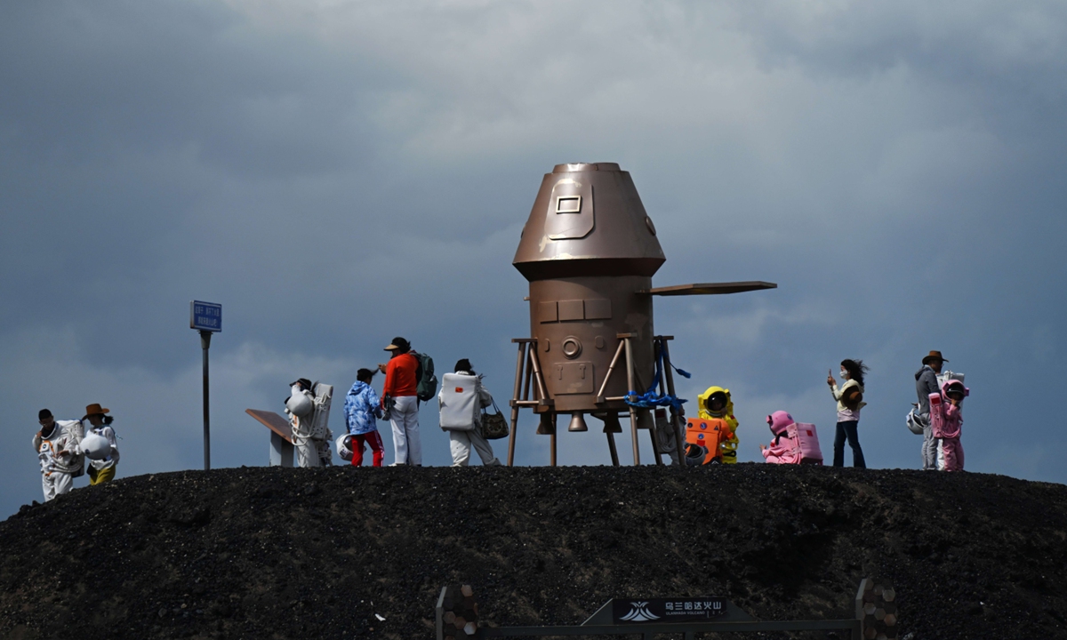 Visitors wearing spacesuits take part in the 
