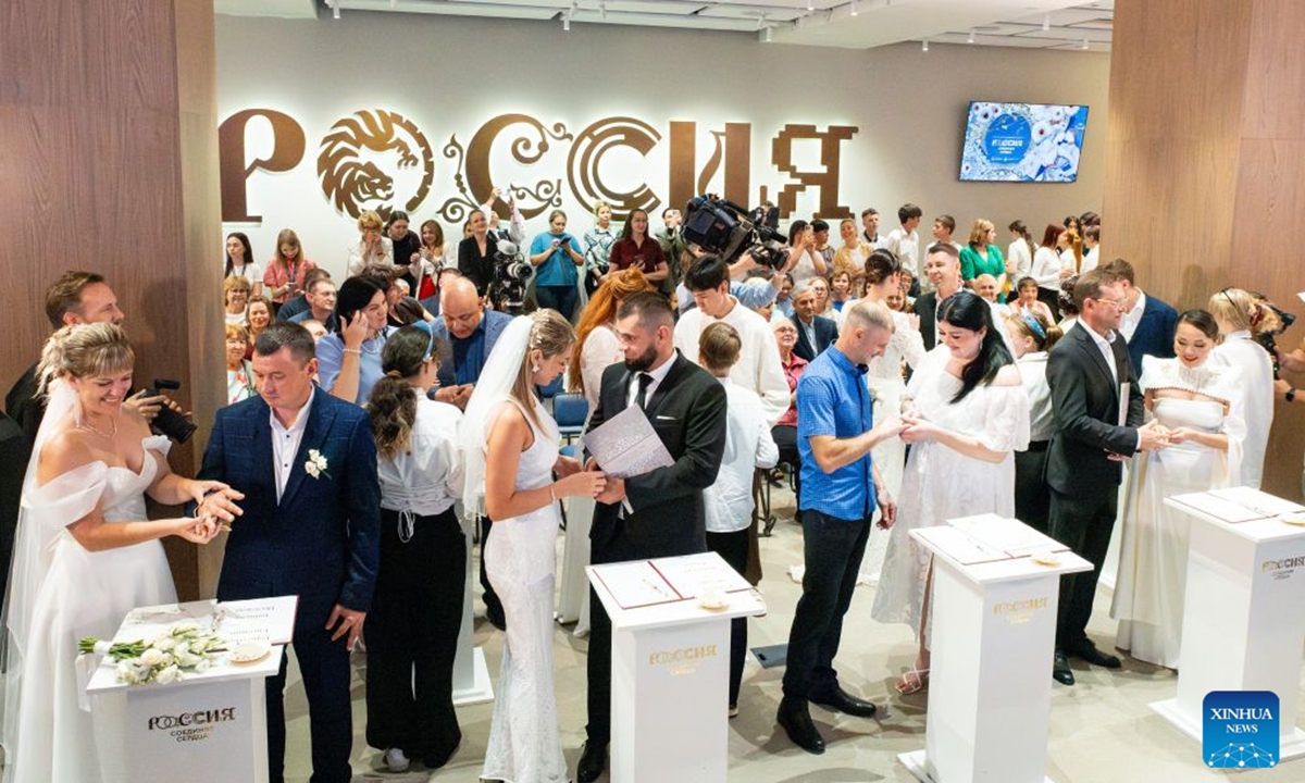Newlyweds exchange rings during a group wedding in Vladivostok, Russia, July 8, 2026. Vladivostok held a Wedding Festival on Wednesday, with 11 couples registering their marriages and participating in a group wedding. (Photo by Andrey Matveenko/Xinhua)