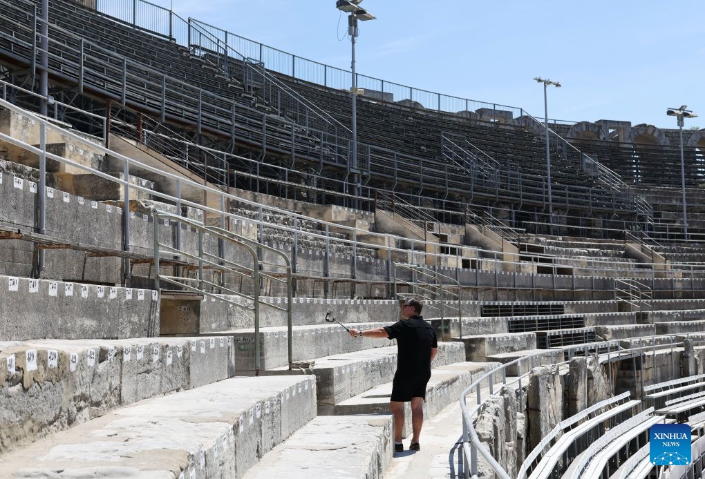 A tourist takes selfies in the Arles Amphitheatre in Arles, France, on July 8, 2026. (Xinhua/Wu Huiwo)