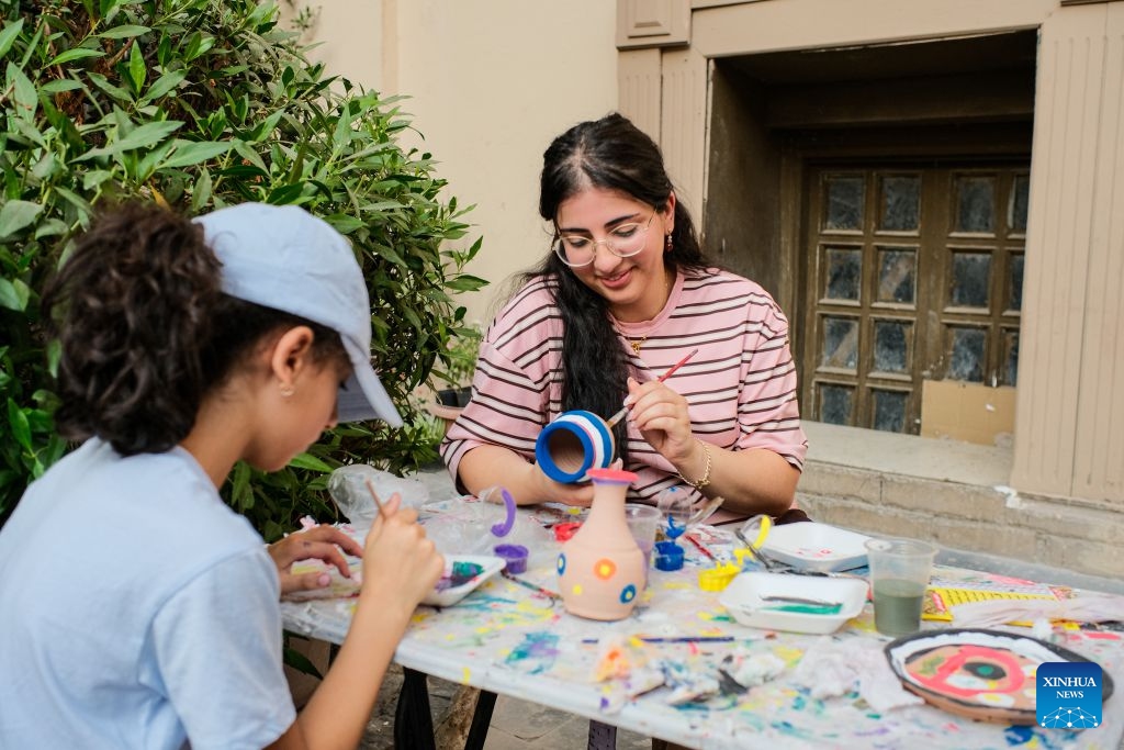 Tourists experience pottery painting in downtown Cairo, Egypt, July 9, 2026. Egypt's government recently launched the Street of Art initiative, aiming to transform the streets and squares of the capital, Cairo, into open-air cultural spaces. Every Thursday through Saturday evening, the public can enjoy free cultural activities such as poetry readings, musical performances, and visual art exhibitions, attracting active participation from both citizens and tourists. (Xinhua/Xin Mengchen)