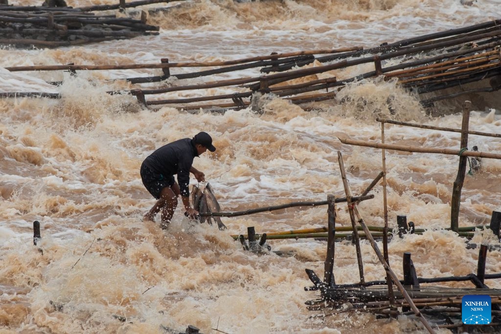 A fisherman catches fish in the Mekong River in Champasak Province, Laos, July 10, 2026. Champasak Province in southern Laos is home to the final section of the Mekong River running through the country, and well noted for a diverse array of river fish and rich aquatic resources. Many locals rely on fishing for their livelihood. (Photo: Xinhua)