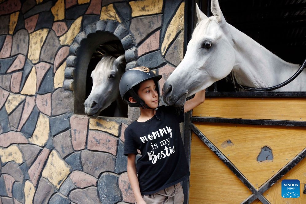 A boy poses for a photo with a horse at an equestrian club in Sanaa, Yemen, on July 9, 2026. Horse lovers and trainers gathered at an equestrian club in Yemen's capital Sanaa to promote equestrian culture and encourage horse riding ahead of World Horse Day, which falls on July 11. (Photo: Xinhua)