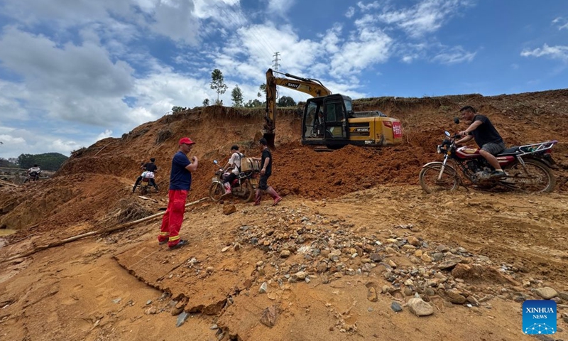 This photo taken with a mobile phone shows rescuers clearing up a road leading to Zhenlong Township in Hengzhou, south China's Guangxi Zhuang Autonomous Region, July 10, 2026.(Xinhua/Huang Xiaobang)

