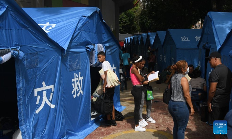 People affected by two earthquakes are seen at a temporary camp set up with tents donated by China, in Catia la Mar, La Guaira state, Venezuela, on July 10, 2026. On the streets of Catia la Mar, a coastal town in La Guaira state and among the areas hit hardest by Venezuela's June 24 twin earthquakes, China's humanitarian aid has become a visible presence. (Photo by Marcos Salgado/Xinhua)
