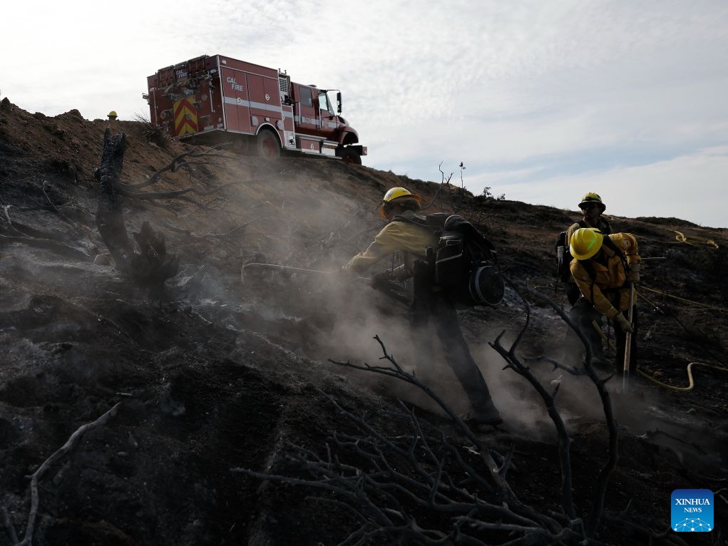 Firefighters mop up debris after battling a brush fire in Antelope Valley, Los Angeles County, California, the United States, July 11, 2026. A wildfire burning in U.S. Southern California exploded to nearly 2,700 acres (about 10.9 square kilometers) Saturday, forcing evacuations amid dangerous heat wave. (Photo by Qiu Chen/Xinhua)