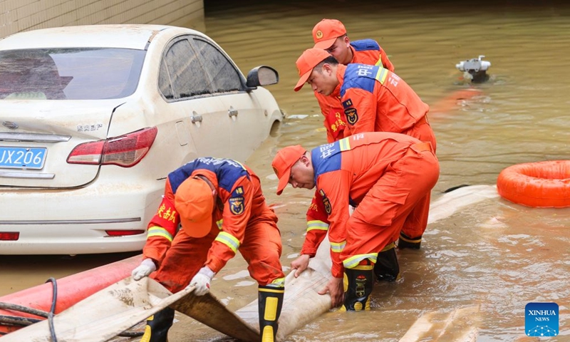 Firefighters from Kunming of southwest China's Yunnan Province pump out stagnant floodwater from a garage in Guigang, south China's Guangxi Zhuang Autonomous Region, July 11, 2026.

