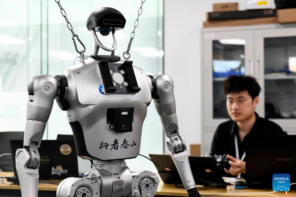 A staff member adjusts a robot at Shandong Yobotics Intelligent Robot Co., Ltd. in Jinan High-tech Industrial Development Zone in Jinan, east China's Shandong Province, July 11, 2026.