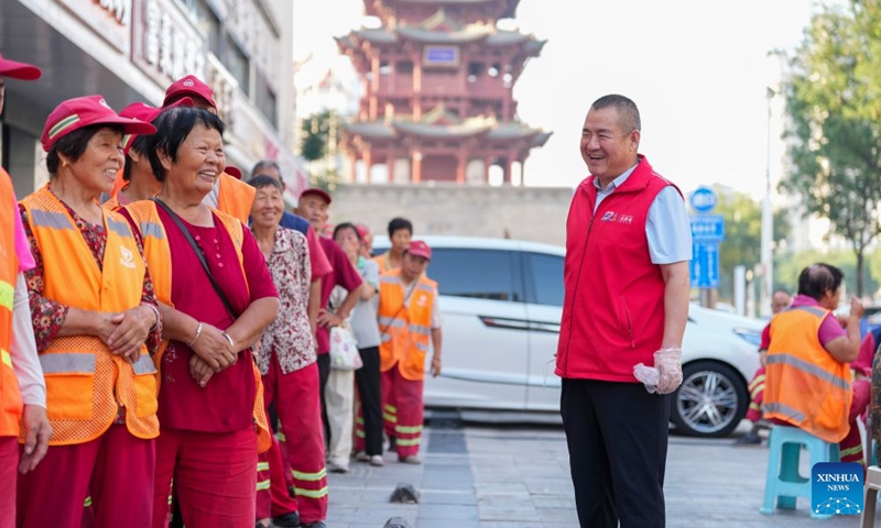 Zhang Changqin (R) talks with sanitation workers in Yanhu District, Yuncheng City, north China's Shanxi Province, July 8, 2026. (Xinhua/Yang Chenguang)

