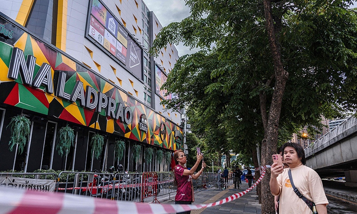 People stand outside the Rong Beer Na Lat Phrao bar in Bangkok, Thailand, on July 13, 2026. A massive fire in the bar late on July 12 killed at least 27 people and injured dozens more. Photo: VCG