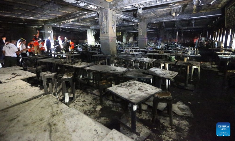 Rescuers work at a pub where a fire broke out in Bangkok, Thailand, July 13, 2026.
